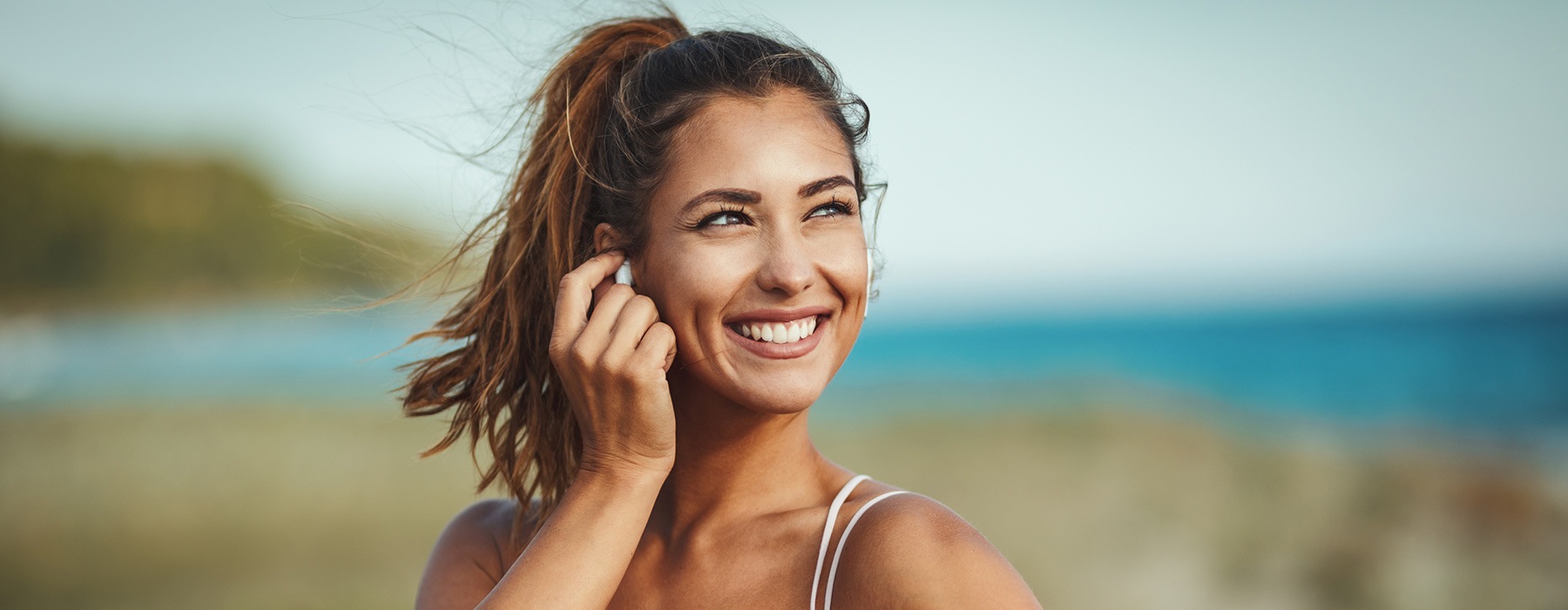 lifestyle image of a woman smiling and looking to the distance outside